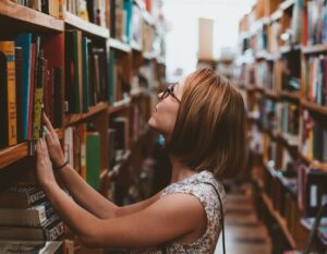 Frau sucht Bücher in Bibliothek