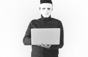 Hacker mit Maske und Laptop